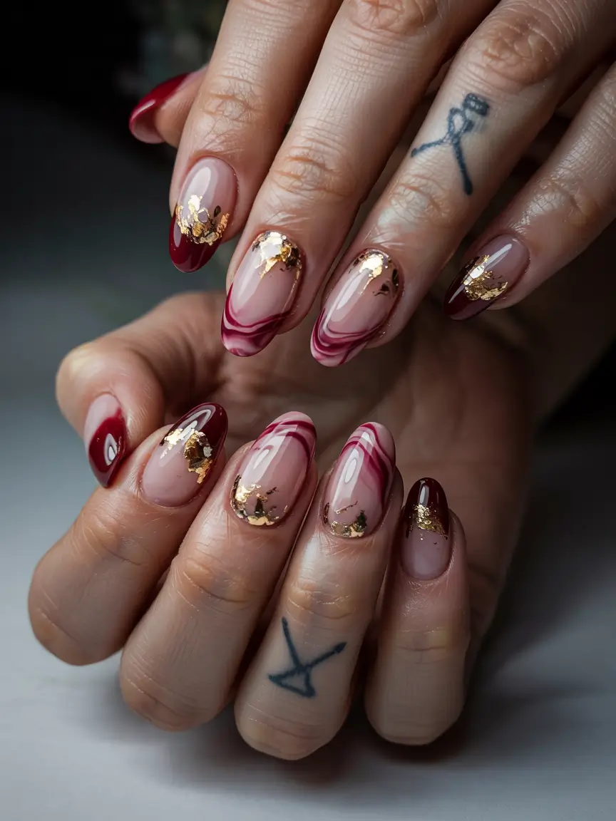 Stylish Nail Ideas for Winter 2025–2026 Crimson Swirls with Gold Foil